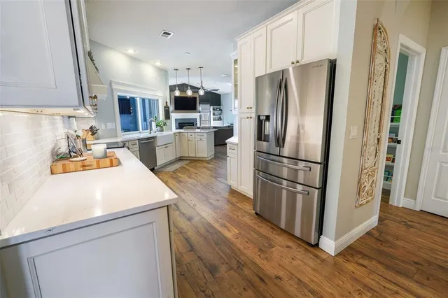 a view of a hallway with wooden floor and a living room