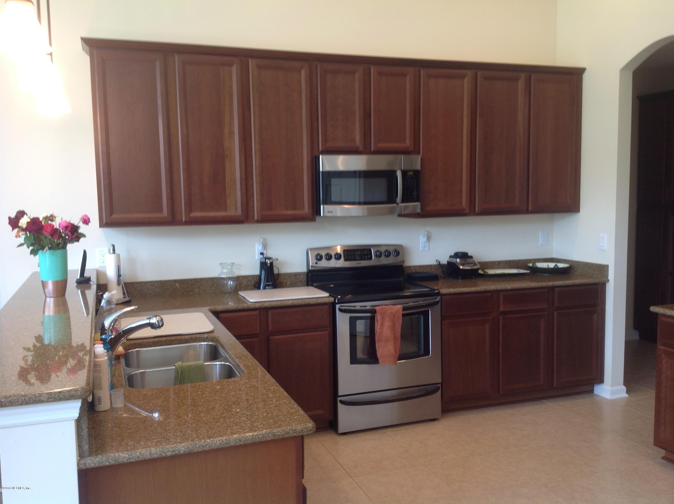 239 Holland Drive St. Augustine, FL 32095 - Photo 4 of 46 a kitchen with sink a microwave and cabinets