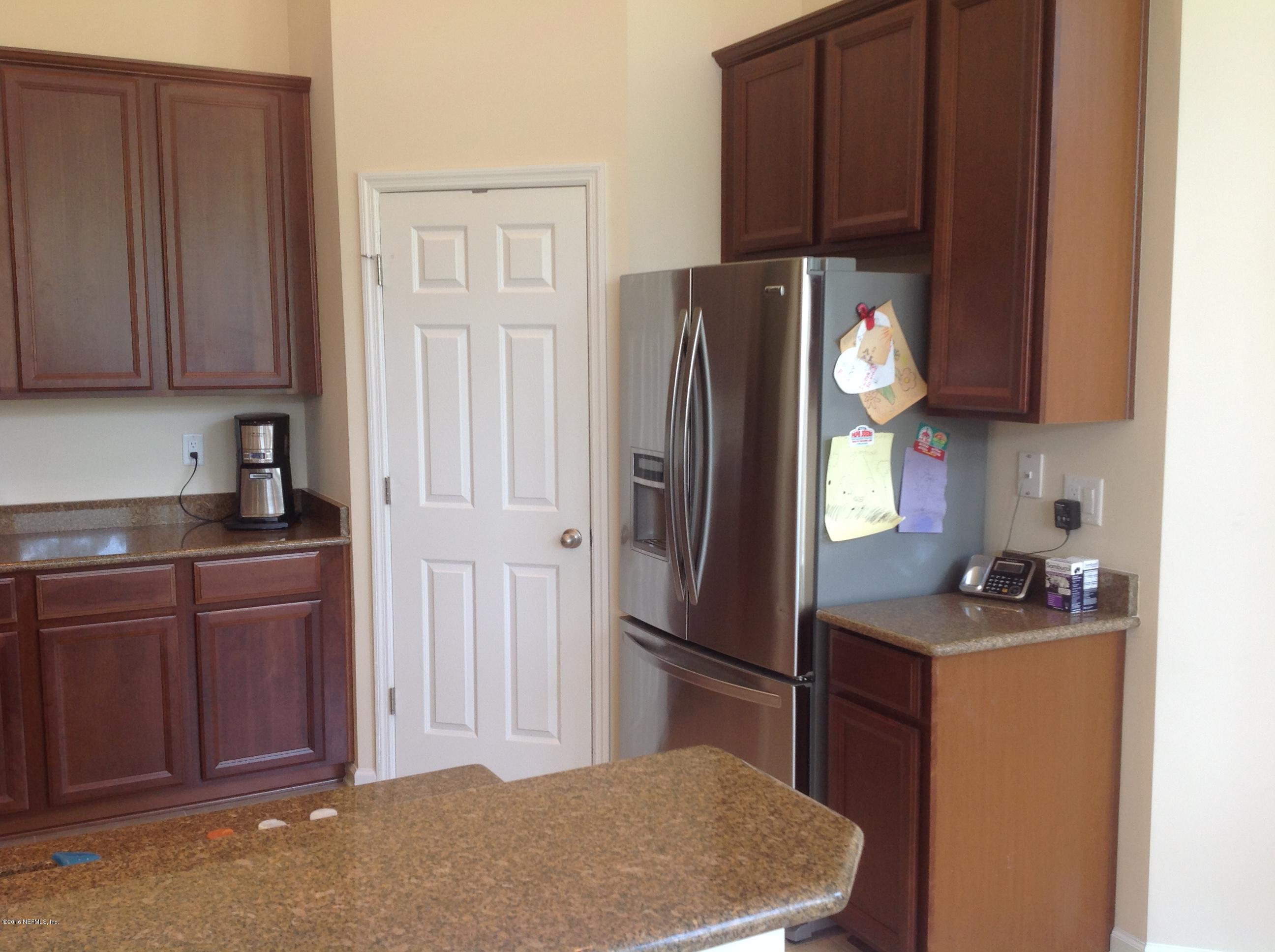239 Holland Drive St. Augustine, FL 32095 - Photo 6 of 46 a kitchen with a refrigerator and cabinets
