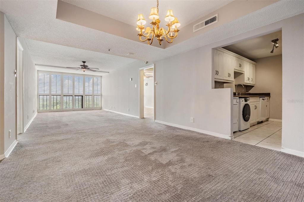 3211 West Swann Avenue, Unit 907 Tampa, FL 33609 - Photo 12 of 32 a view of livingroom with chandelier fan and kitchen view
