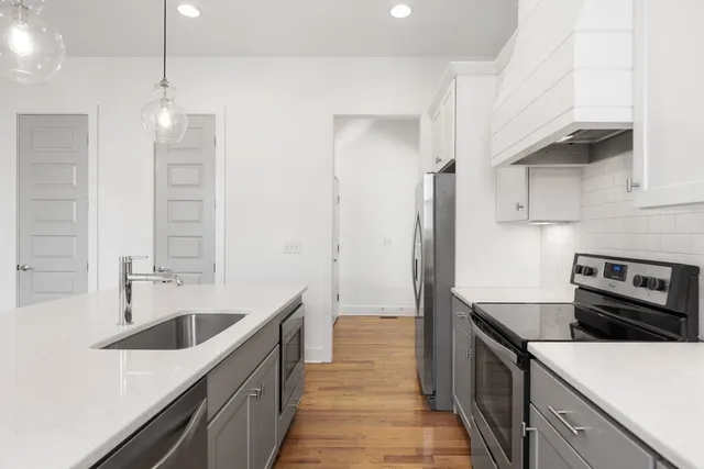 a kitchen with kitchen island a sink appliances and cabinets