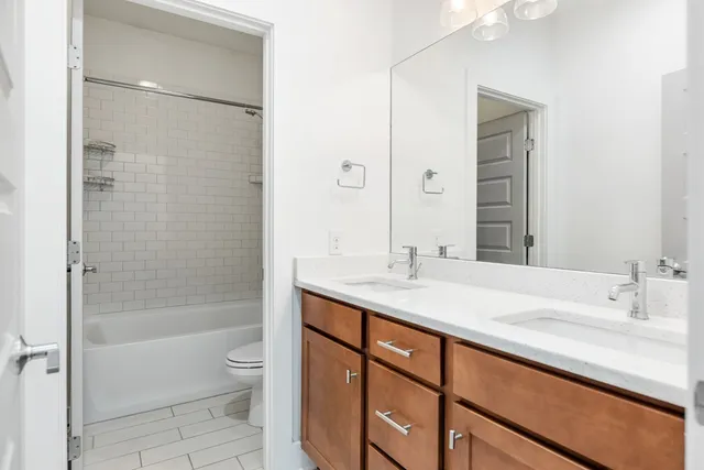 a bathroom with a sink toilet double vanity and shower