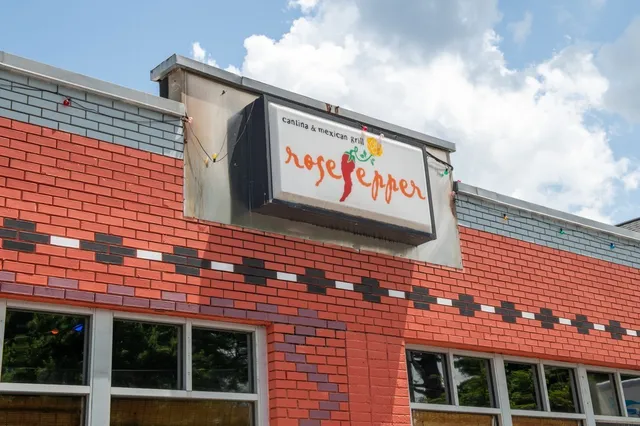 a sign board with a brick wall