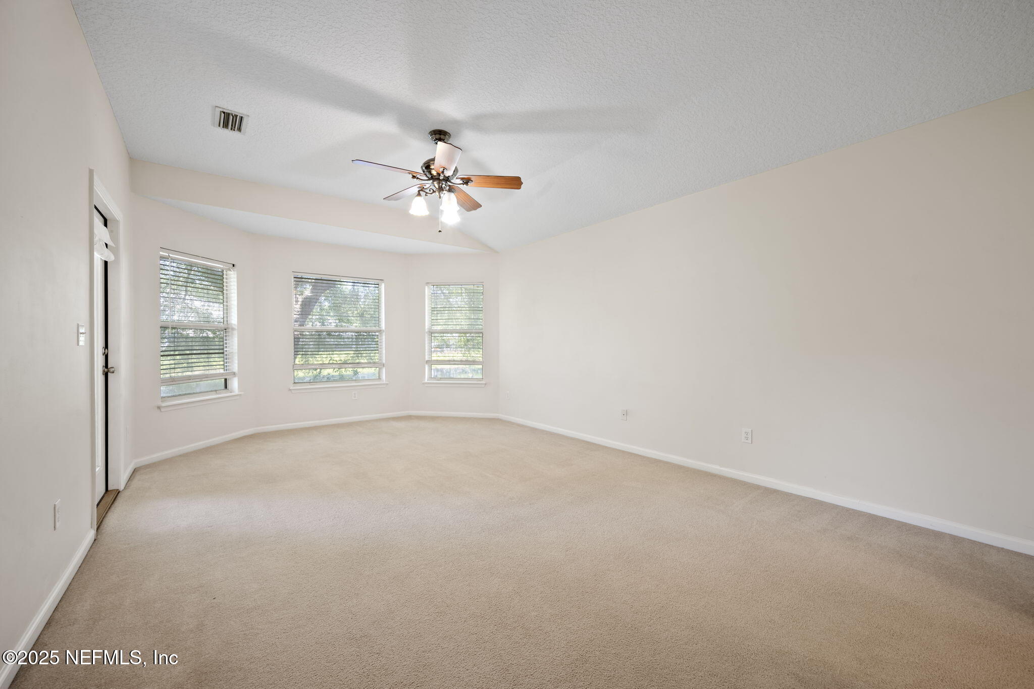 96316 Ridgewood Circle Fernandina Beach, FL 32034 - Photo 15 of 32 an empty room with windows and chandelier fan