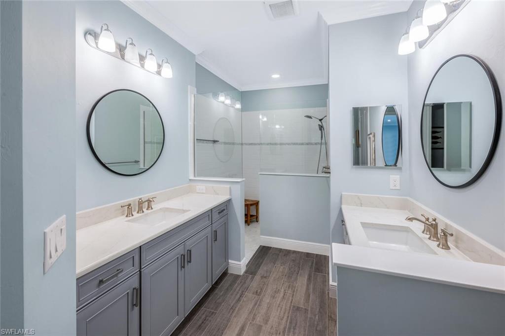 2211 Marquesa Circle Naples, FL 34112 - Photo 14 of 28 a bathroom with a double vanity sink and a mirror