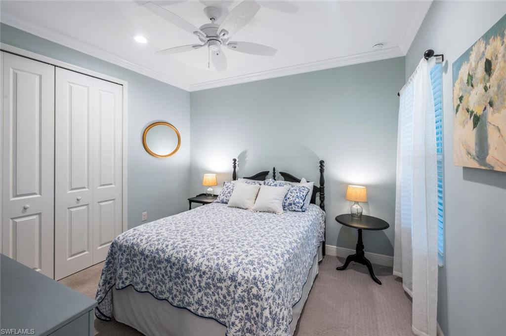 2211 Marquesa Circle Naples, FL 34112 - Photo 17 of 28 a bedroom with a bed and a chandelier