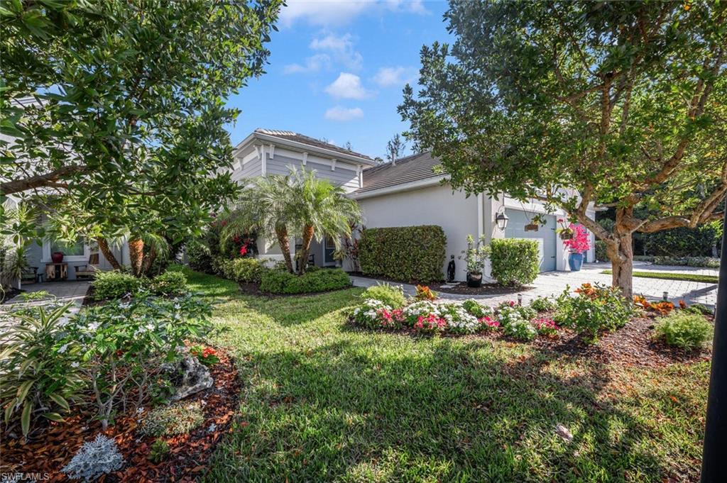 2211 Marquesa Circle Naples, FL 34112 - Photo 22 of 28 a front view of a house with a yard and plant