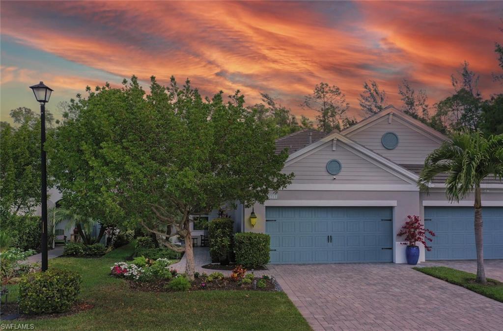 2211 Marquesa Circle Naples, FL 34112 - Photo 23 of 28 a front view of a house with a garden and trees