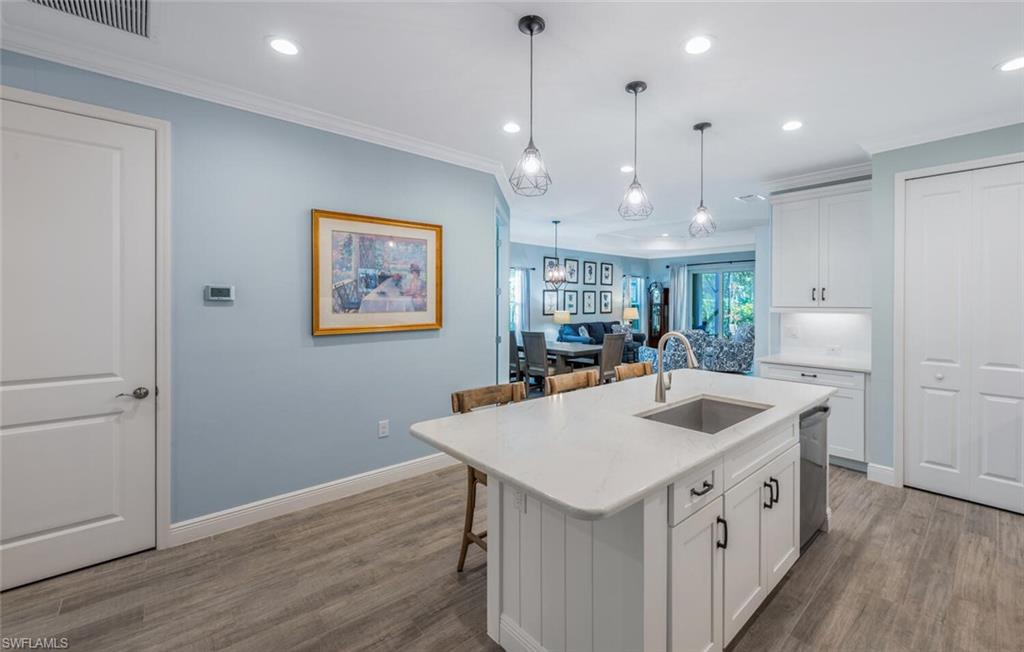 2211 Marquesa Circle Naples, FL 34112 - Photo 7 of 28 a kitchen that has a sink a stove a microwave oven a counter space and wooden floor