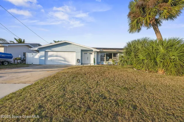 a view of a house with a yard and a garage