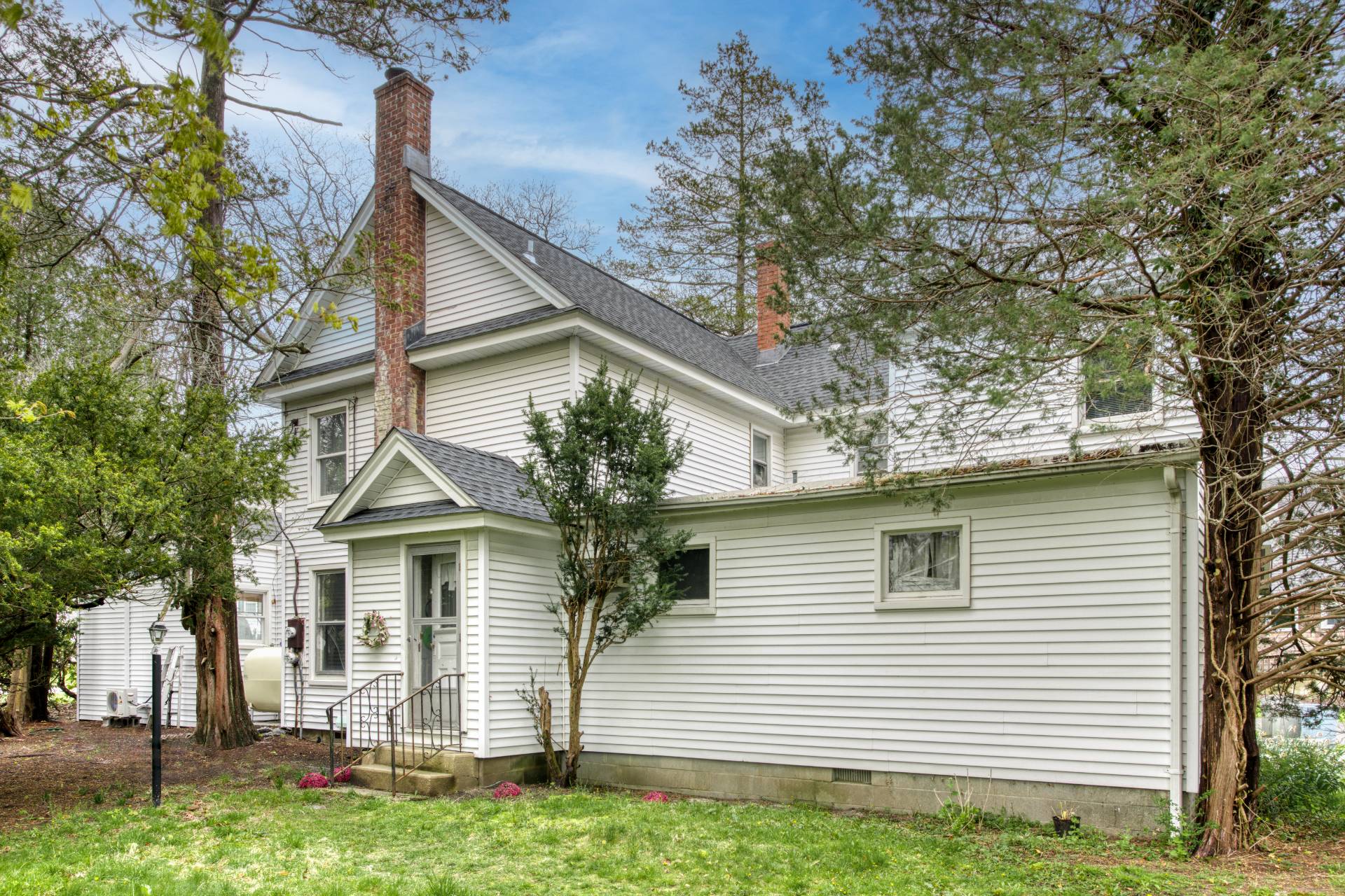 57 Mill Road Westhampton Beach, NY 11978 - Photo 8 of 20 a view of a white house with a small yard and a large tree