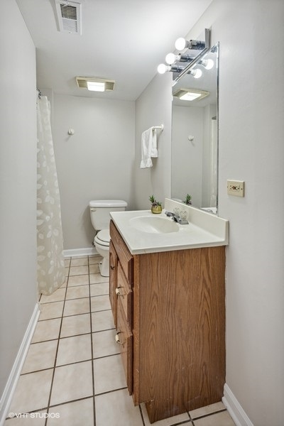 208 South Rush Street Itasca, IL 60143 - Photo 27 of 33 a en suite bathroom with a sink a toilet and a mirror