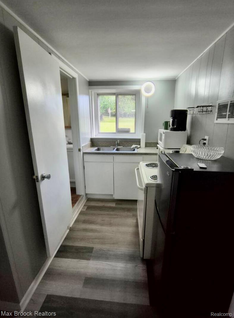 1392 Maple Grove Road Lapeer, MI 48446 - Photo 59 of 70 Kitchen featuring white cabinetry, dark wood-style flooring, white appliances, and light countertops