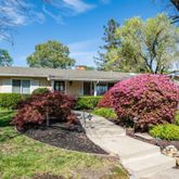 a front view of a house with a yard and potted plants