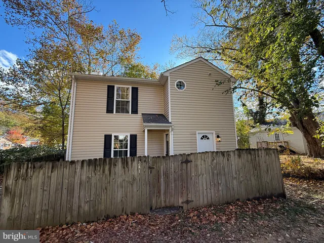 a view of a house with a wooden fence