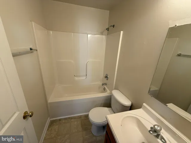 a white toilet sitting next to a bath tub