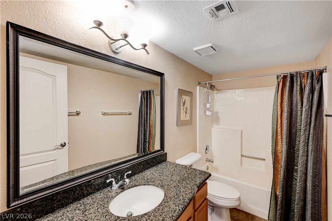 9325 West Desert Inn Road, Unit 226 Las Vegas, NV 89117 - Photo 17 of 29 Granite counters and a framed mirror elevate this complete bathroom vanity.