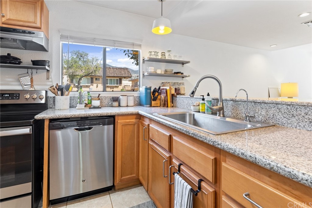 350 Burchett Street, Unit 101 Glendale, CA 91203 - Photo 3 of 27 a kitchen with stainless steel appliances granite countertop a sink a stove cabinets counter space and a window
