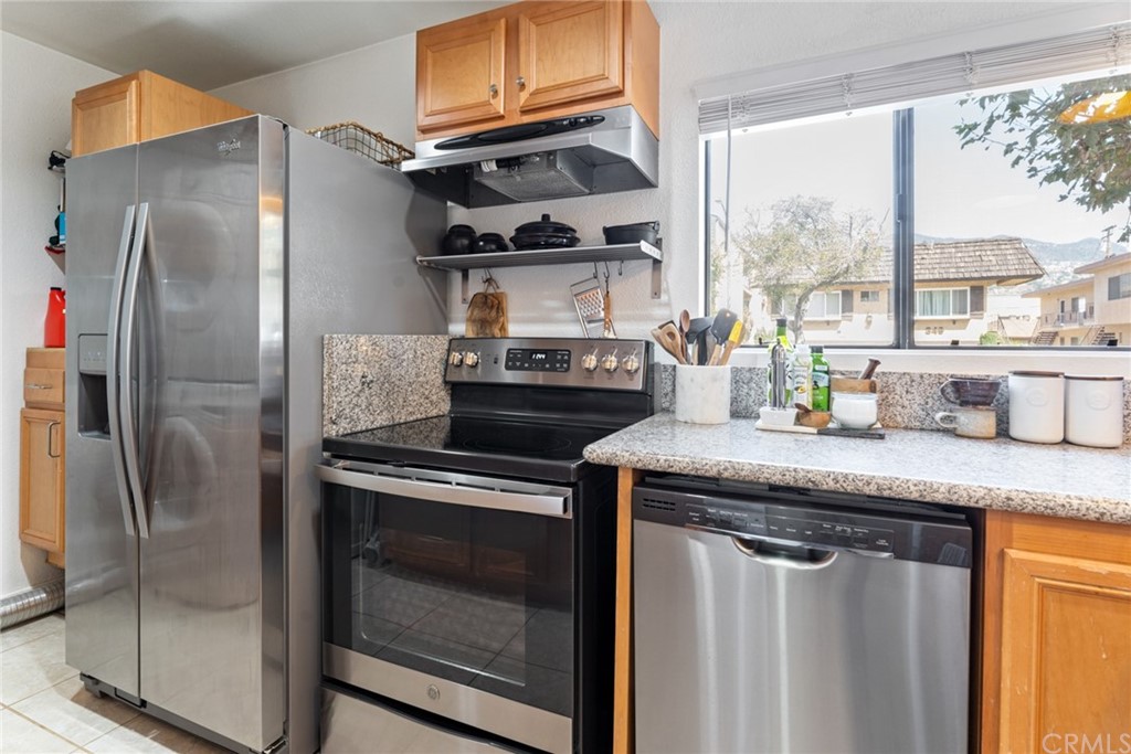 350 Burchett Street, Unit 101 Glendale, CA 91203 - Photo 4 of 27 a kitchen with stainless steel appliances granite countertop a sink and a refrigerator