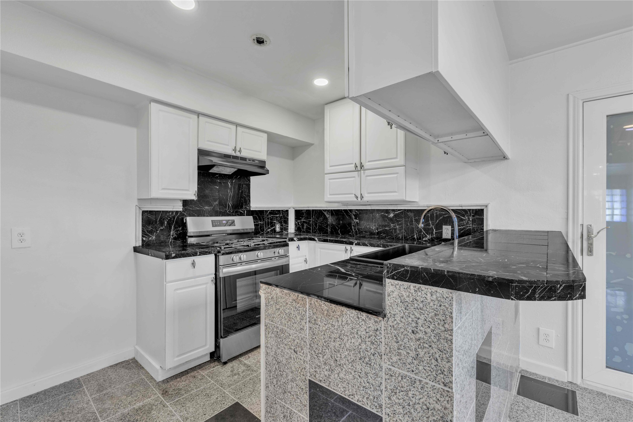 5210 Woodrow Avenue, Unit B Austin, TX 78756 - Photo 1 of 23 a kitchen with granite countertop a sink stainless steel appliances and cabinets