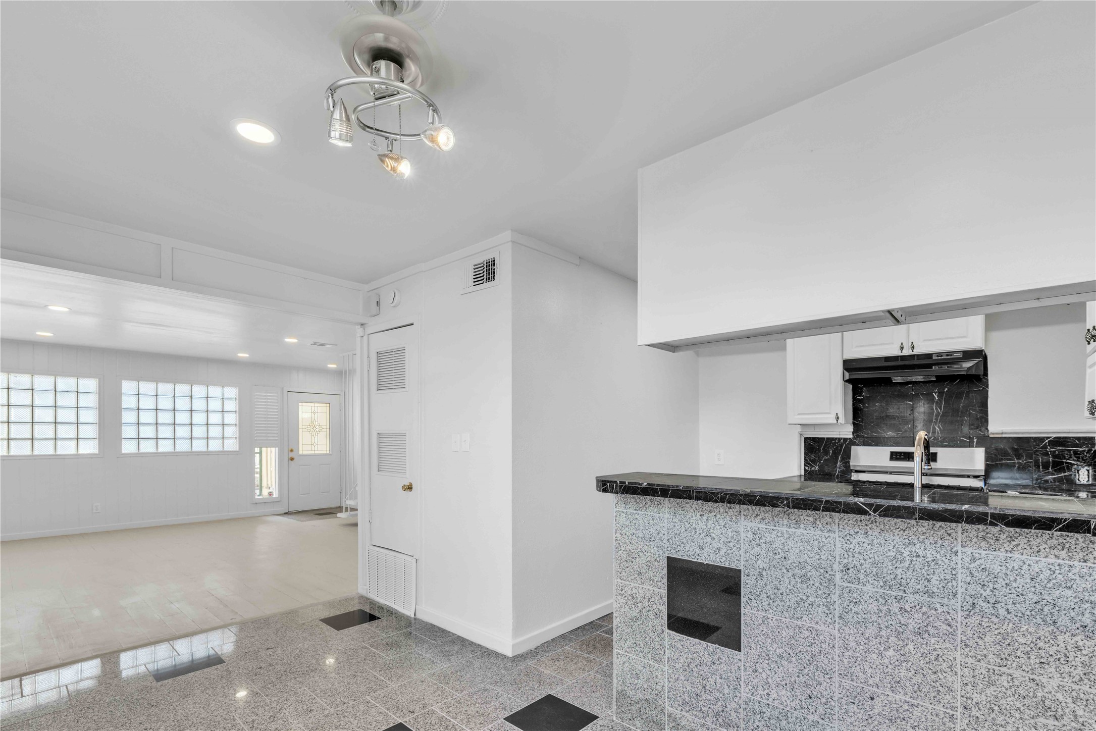 5210 Woodrow Avenue, Unit B Austin, TX 78756 - Photo 5 of 23 a kitchen with kitchen island granite countertop a stove and a sink with cabinets
