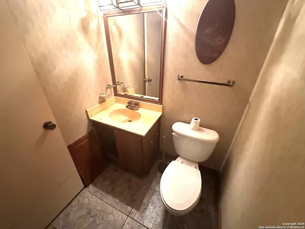 a bathroom with a toilet sink and mirror