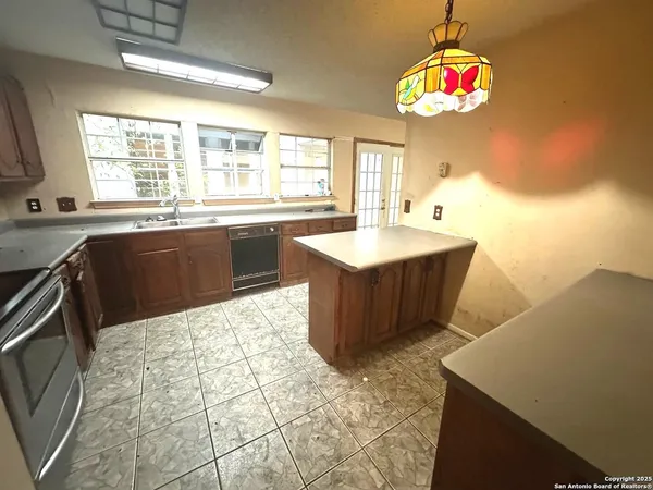 a kitchen with a sink a stove a microwave a dining table and chairs