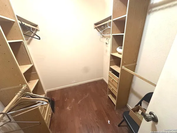 a view of walk in closet with empty racks