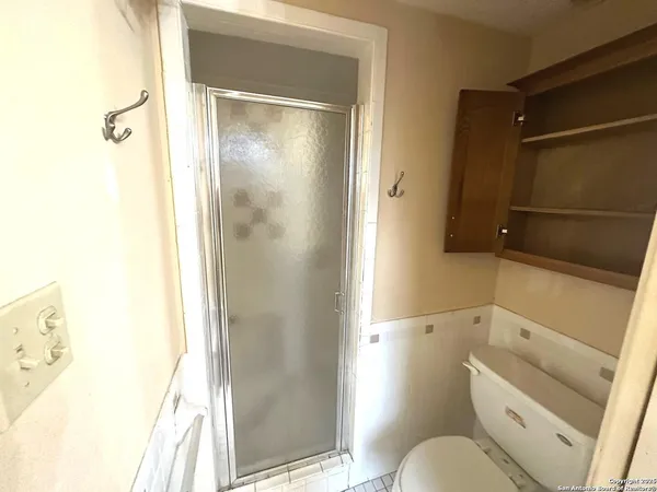 a bathroom with a granite countertop sink toilet and shower
