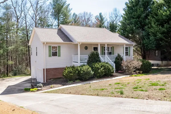a front view of house with yard and trees around