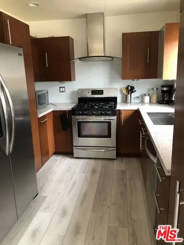 a kitchen with stainless steel appliances granite countertop a stove a sink and a refrigerator