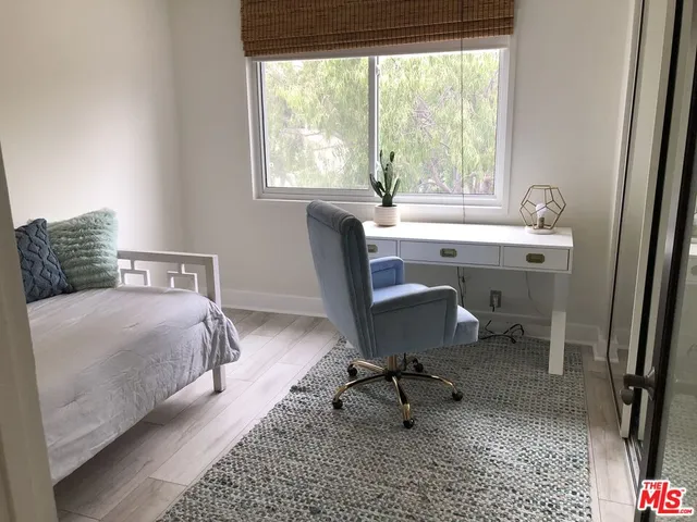 a bedroom with a bed a table and a window