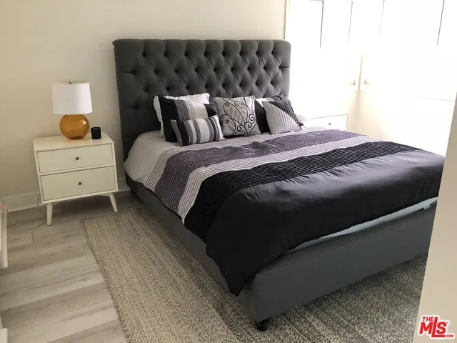 a bed sitting in a bedroom next to a window with dresser