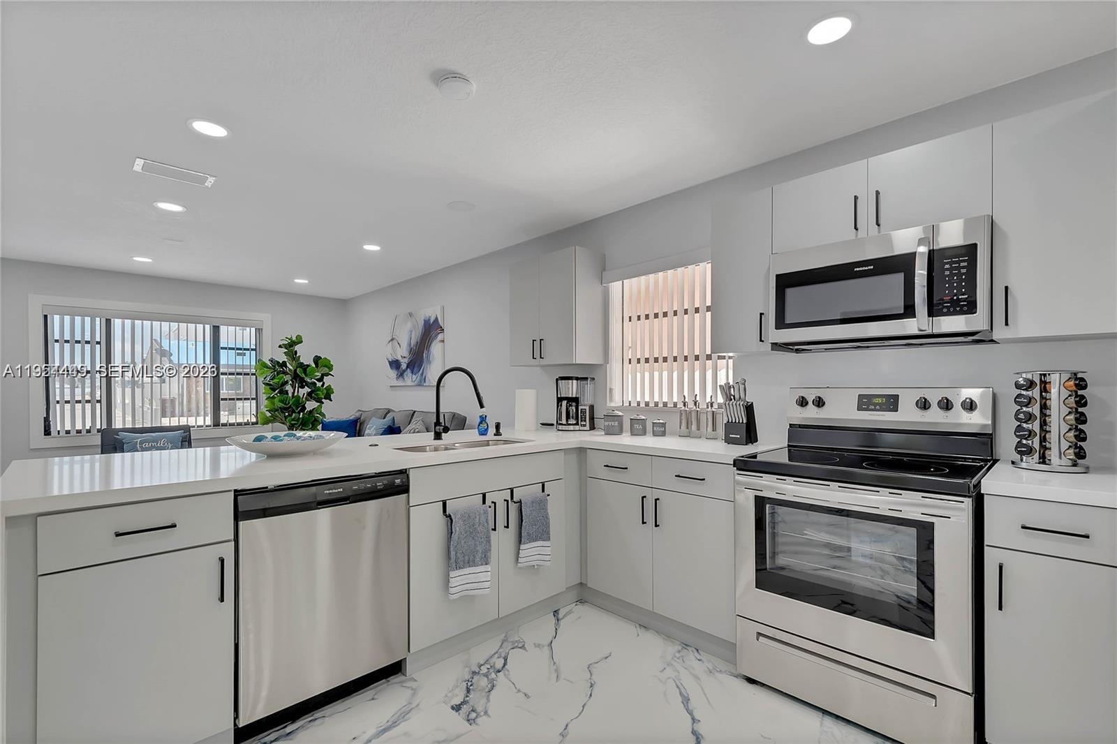 895 West 39th Place, Unit 1 Hialeah, FL 33012 - Photo 11 of 35 a kitchen with white cabinets and appliances