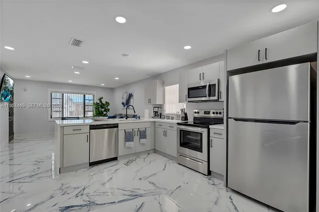a kitchen with white cabinets and stainless steel appliances