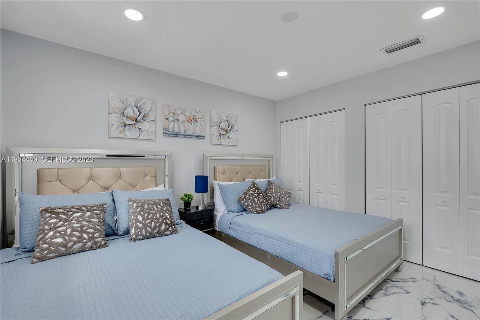 895 West 39th Place, Unit 1 Hialeah, FL 33012 - Photo 14 of 35 a bedroom with a large bed and a chandelier