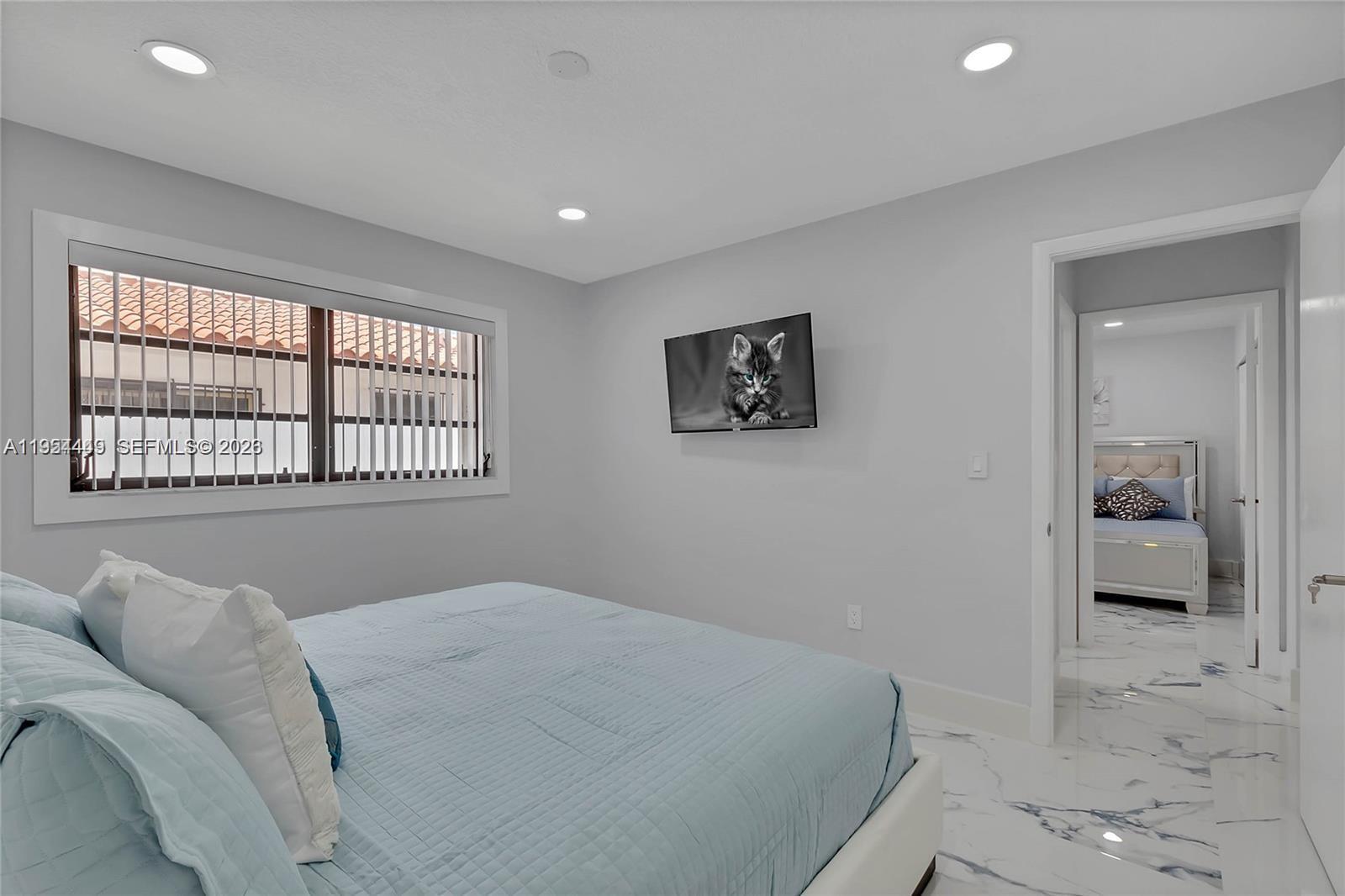 895 West 39th Place, Unit 1 Hialeah, FL 33012 - Photo 16 of 35 a bedroom with a bed and a view of bathroom