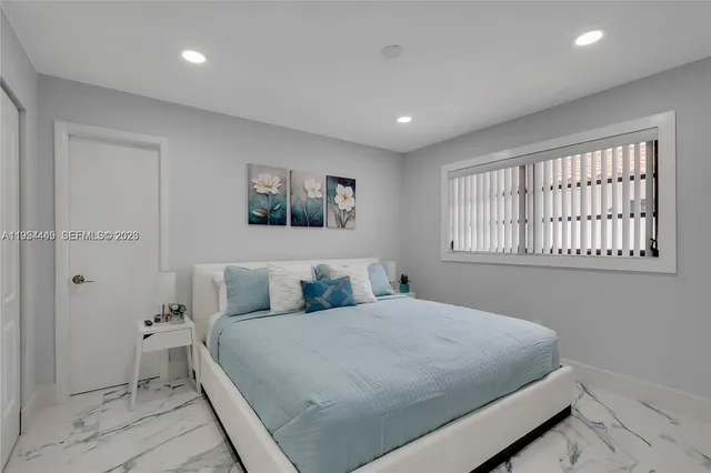 a bedroom with a bed and painting on the wall