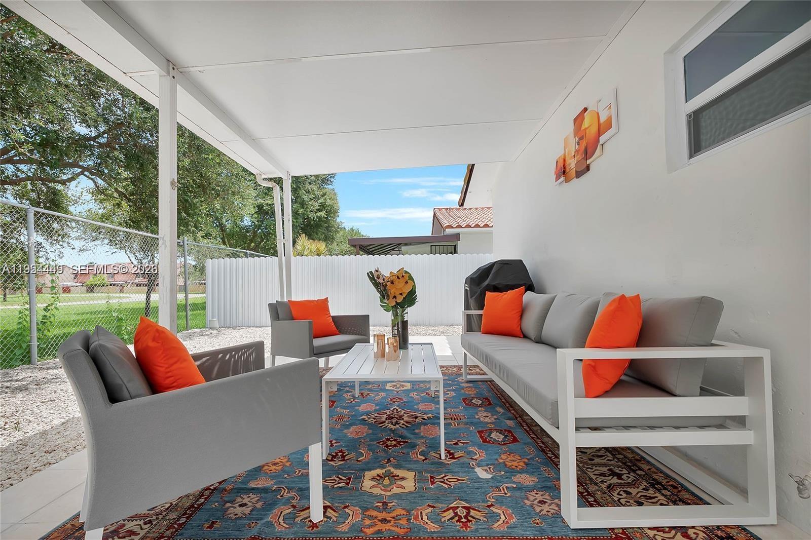 895 West 39th Place, Unit 1 Hialeah, FL 33012 - Photo 32 of 35 a living room with furniture a rug and a floor to ceiling window