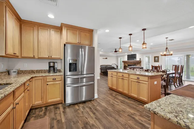 a kitchen with stainless steel appliances granite countertop a refrigerator stove and sink
