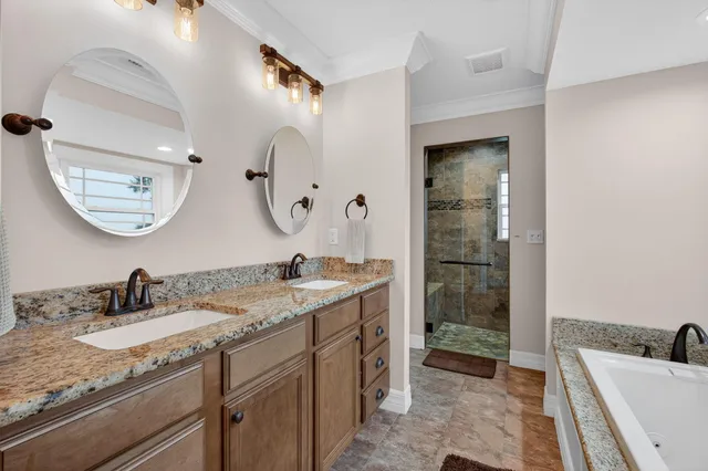 a bathroom with a toilet a double vanity sink and a bathtub