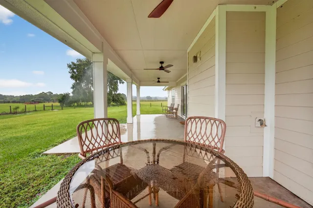 a view of a patio with wooden chairs