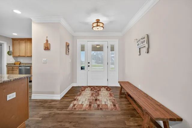 a view of a dining room and livingroom with furniture wooden floor a chandelier