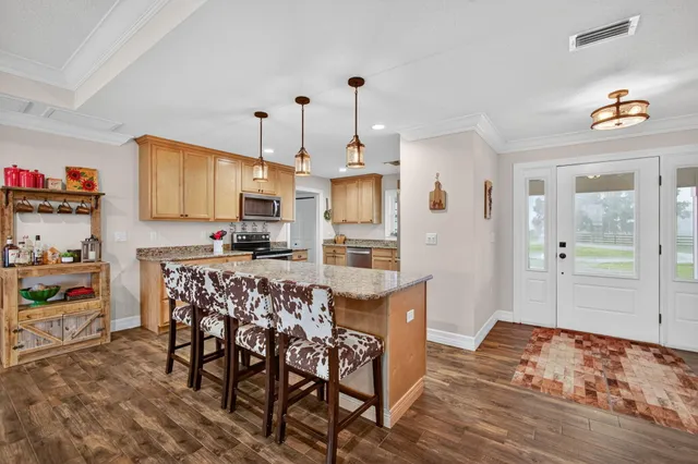 a kitchen with granite countertop a refrigerator stove top oven and sink