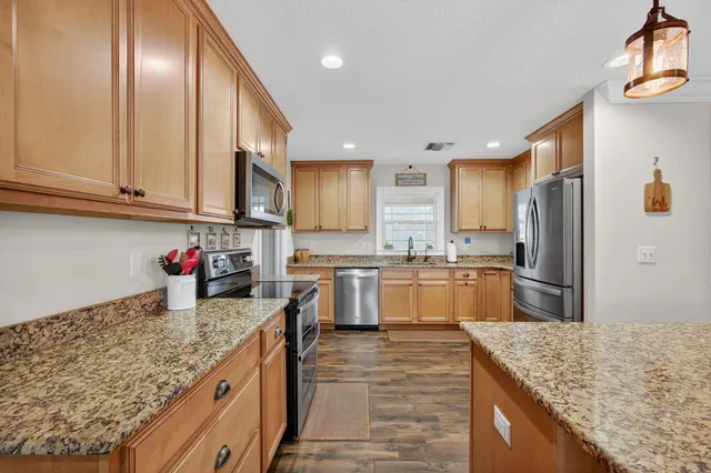 a kitchen with granite countertop a stove top oven sink and cabinets