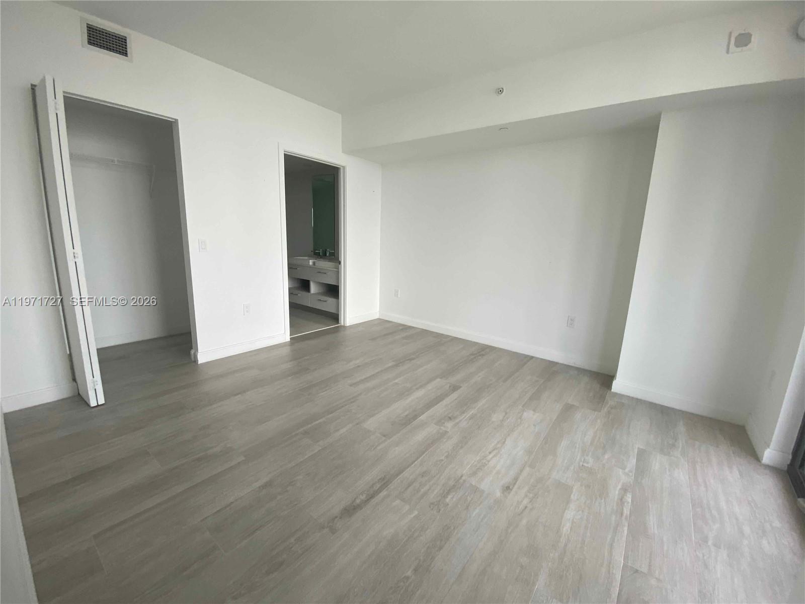 45 Southwest 9th Street, Unit 3703 Miami, FL 33130 - Photo 12 of 73 a view of an empty room with wooden floor and a window