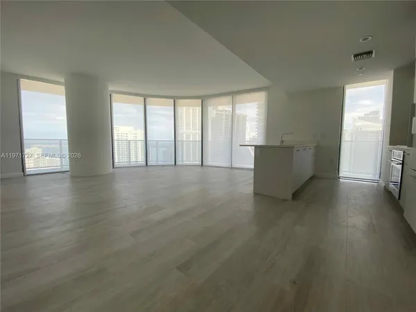 an empty room with wooden floor and door