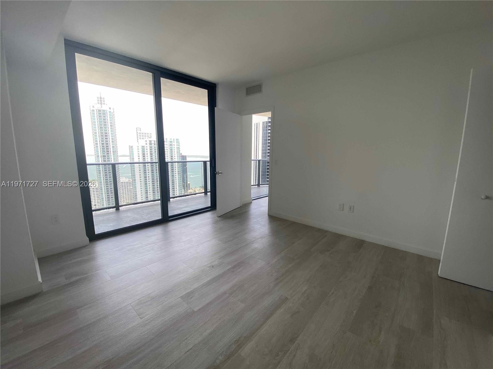 45 Southwest 9th Street, Unit 3703 Miami, FL 33130 - Photo 22 of 73 an empty room with wooden floor and windows