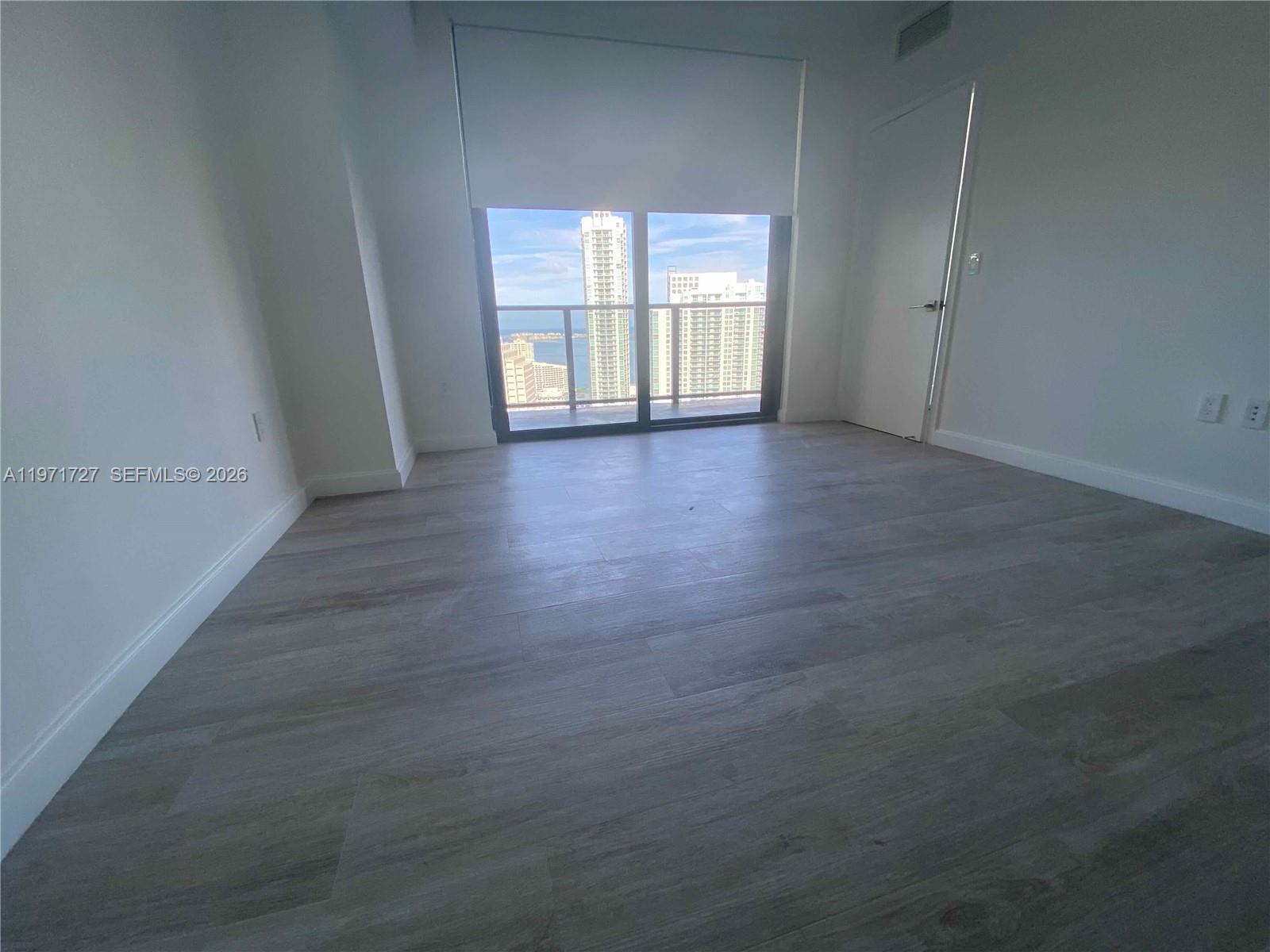 45 Southwest 9th Street, Unit 3703 Miami, FL 33130 - Photo 23 of 73 an empty room with wooden floor and windows