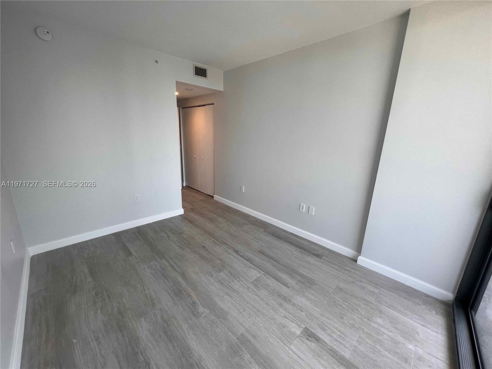 45 Southwest 9th Street, Unit 3703 Miami, FL 33130 - Photo 25 of 73 an empty room with wooden floor and white wall